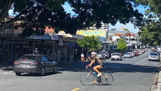 West End image, woman riding bike across the street