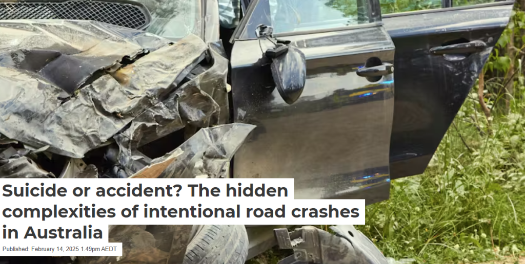 Wrecked black vehicle with severe front-end damage from a crash, parked on a grassy roadside.